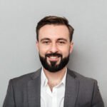 close up portrait young bearded man white shirt jacket posing camera with broad smile isolated gray » Choice Wholesales