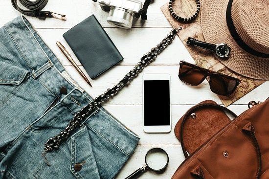 top view accessoires travel with women clothing concept white mobilephone watch bag hat map camera necklace trousers sunglasses white wood table » Choice Wholesales